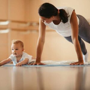 Mujer joven haciendo ejercicio junto a su bebé, para su recuperación al parto o recuperación postparto en Málaga con MaterSana